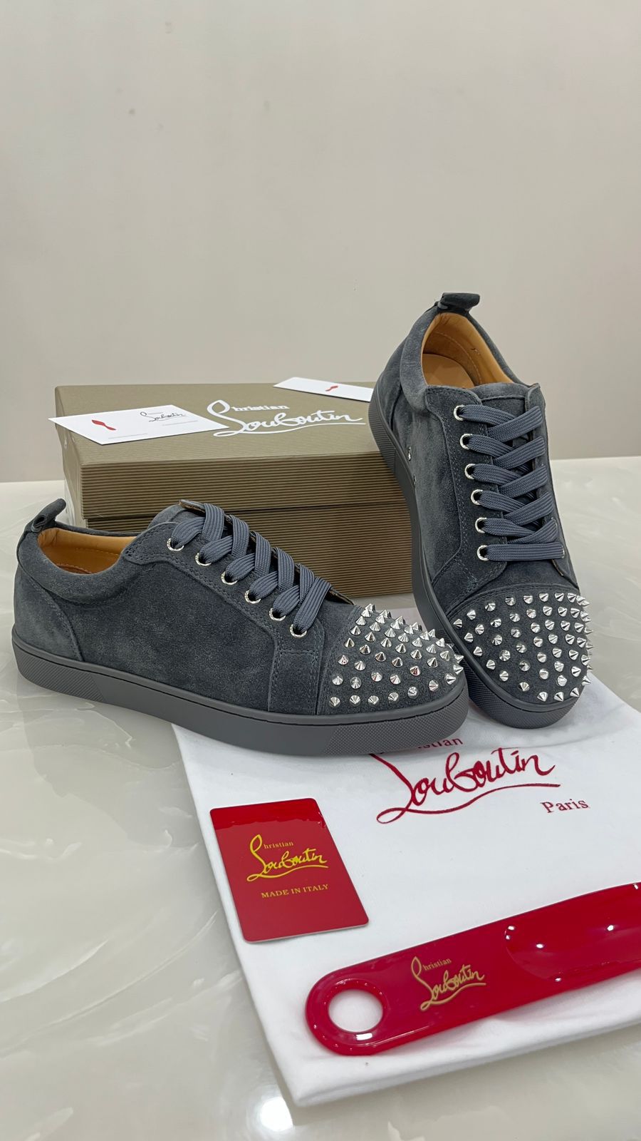 Christian Louboutin Louis Junior Spikes sneakers feature a grey suede